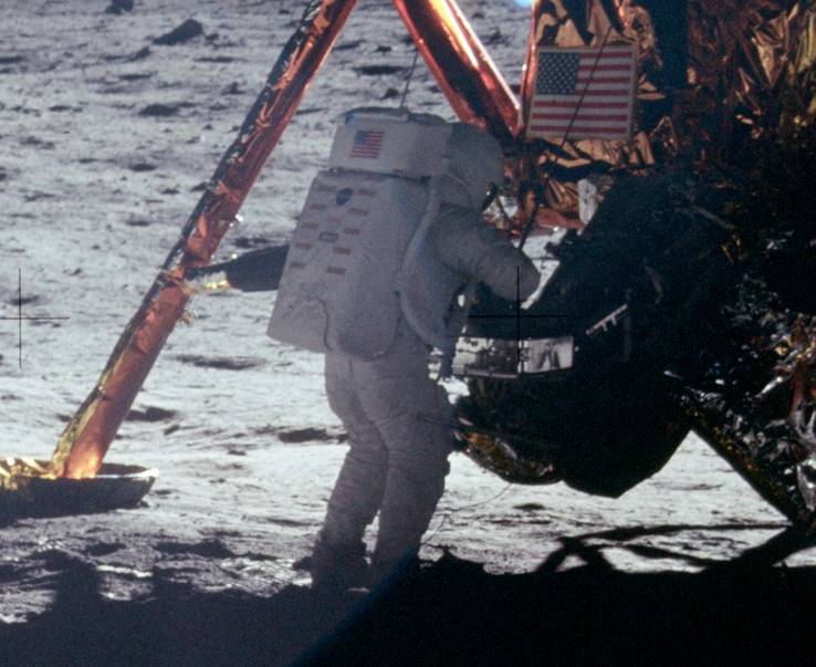 نیل آرمسترانگ در ماه‌نشین بر روی یکی از عکس‌هایی که از سطح ماه گرفته کار می‌کند