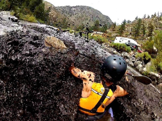 قایقرانی در آب های سیاه و سفید از رودخانه Poudre در کلرادو پس از آتش سوزی جنگل های بزرگ و سیل.